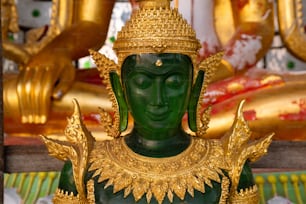 a statue of a green buddha in a temple
