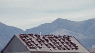 le toit d’une maison avec des montagnes en arrière-plan