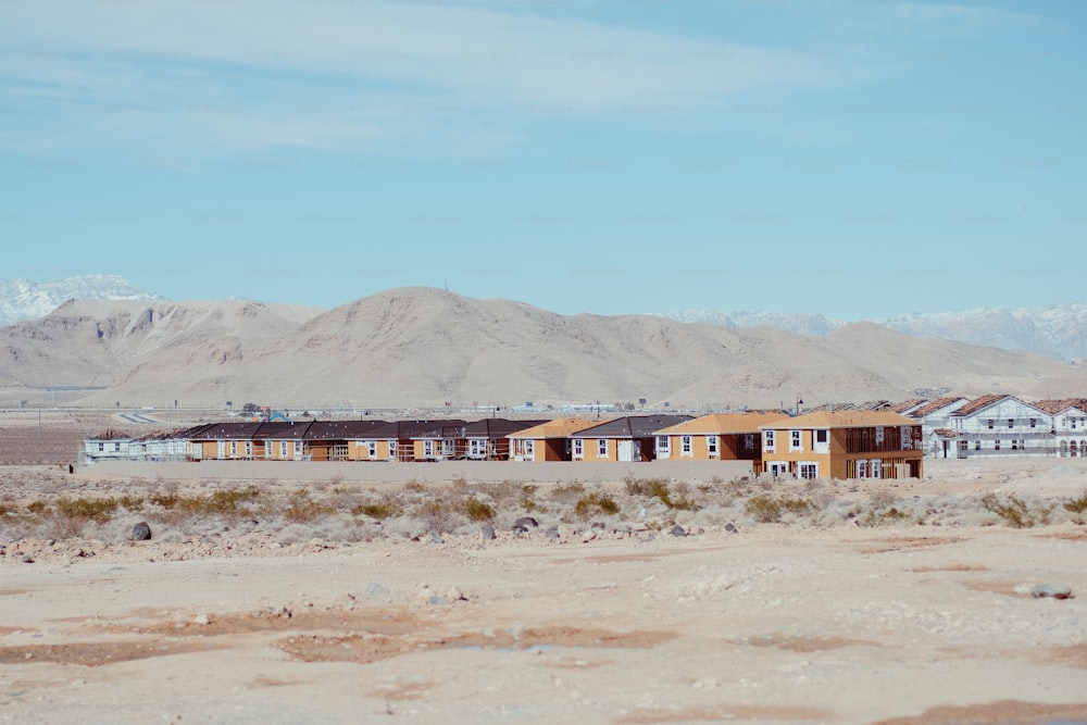 a row of houses in a desert with mountains in the background