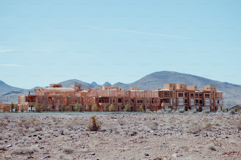 a building in the middle of a desert with mountains in the background