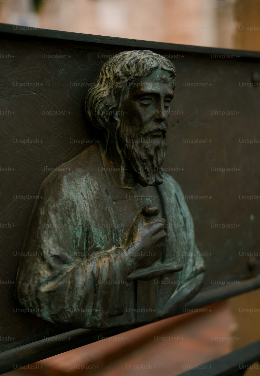 a bronze statue of a man holding a book