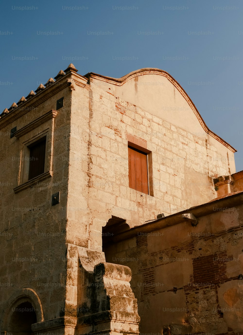 un vieux bâtiment avec une porte et une fenêtre rouges