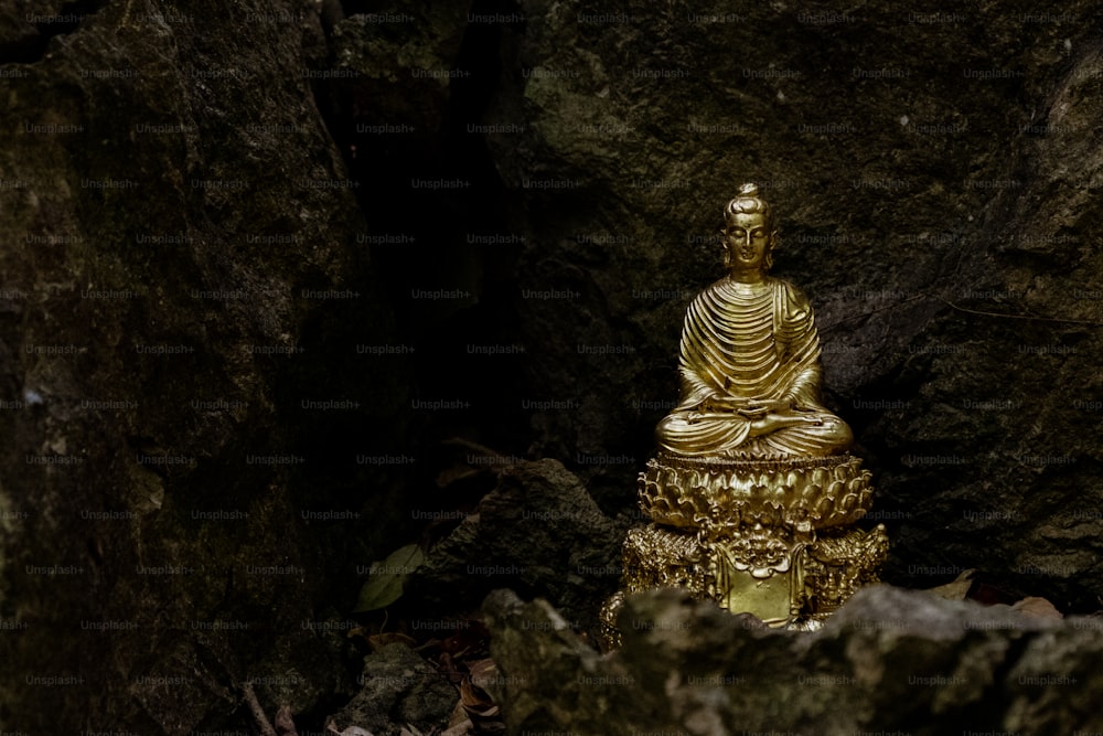 a golden buddha statue sitting in a cave