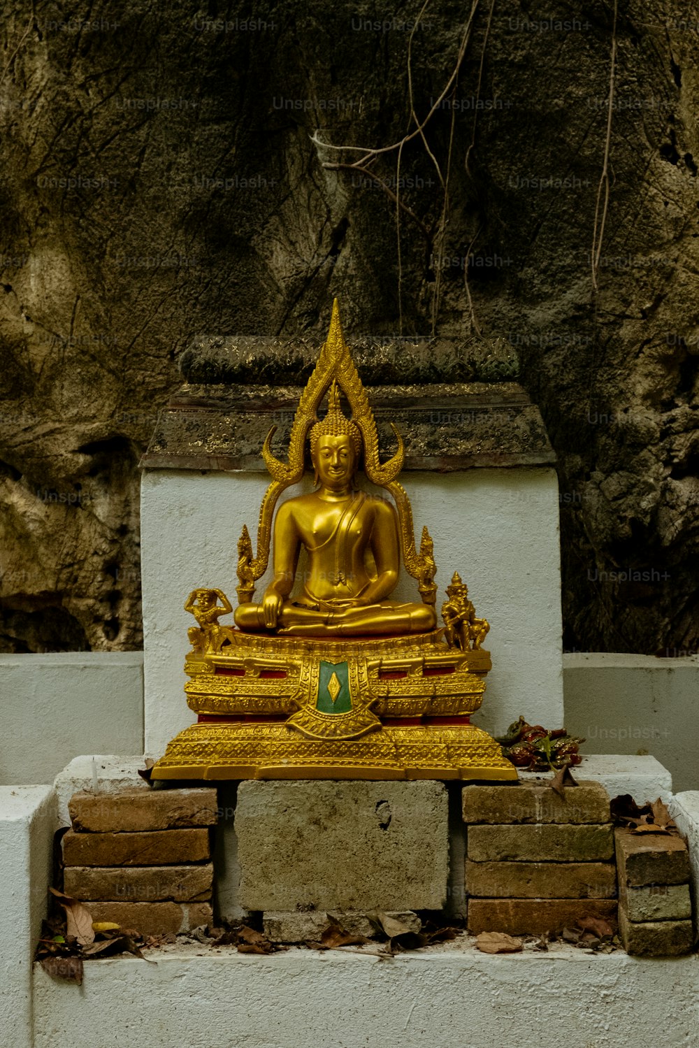 a golden statue sitting on top of a pile of bricks