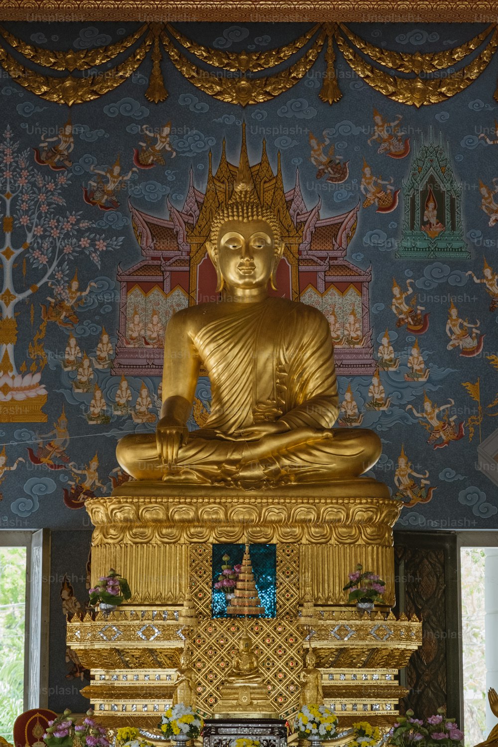 uma estátua dourada de Buda sentada em cima de uma mesa