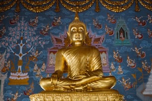 uma estátua dourada de Buda sentada em cima de uma mesa