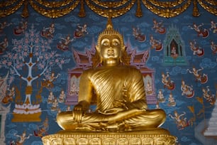 Eine goldene Buddha-Statue sitzt auf einem Tisch