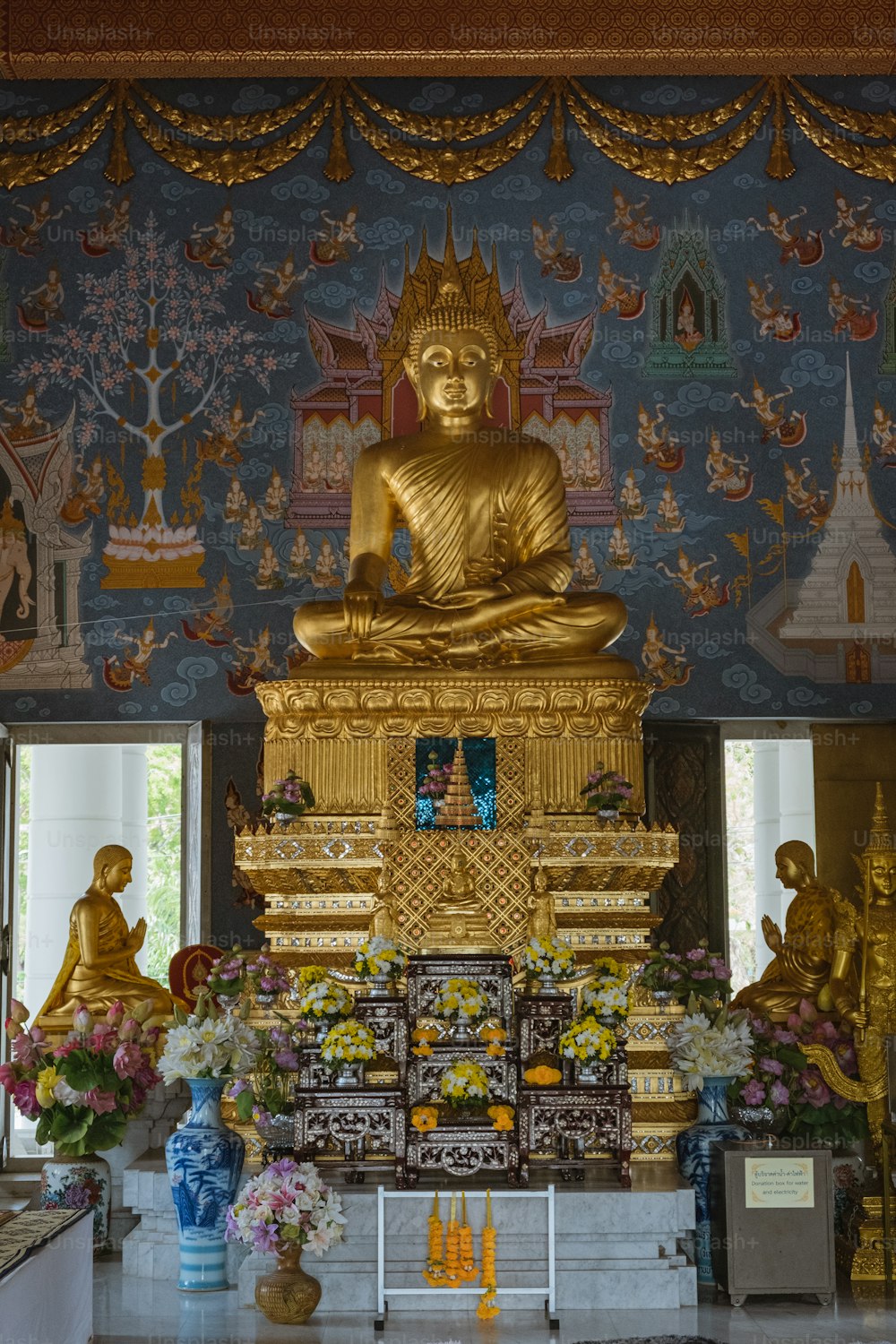 Una grande statua dorata del Buddha seduta in una stanza