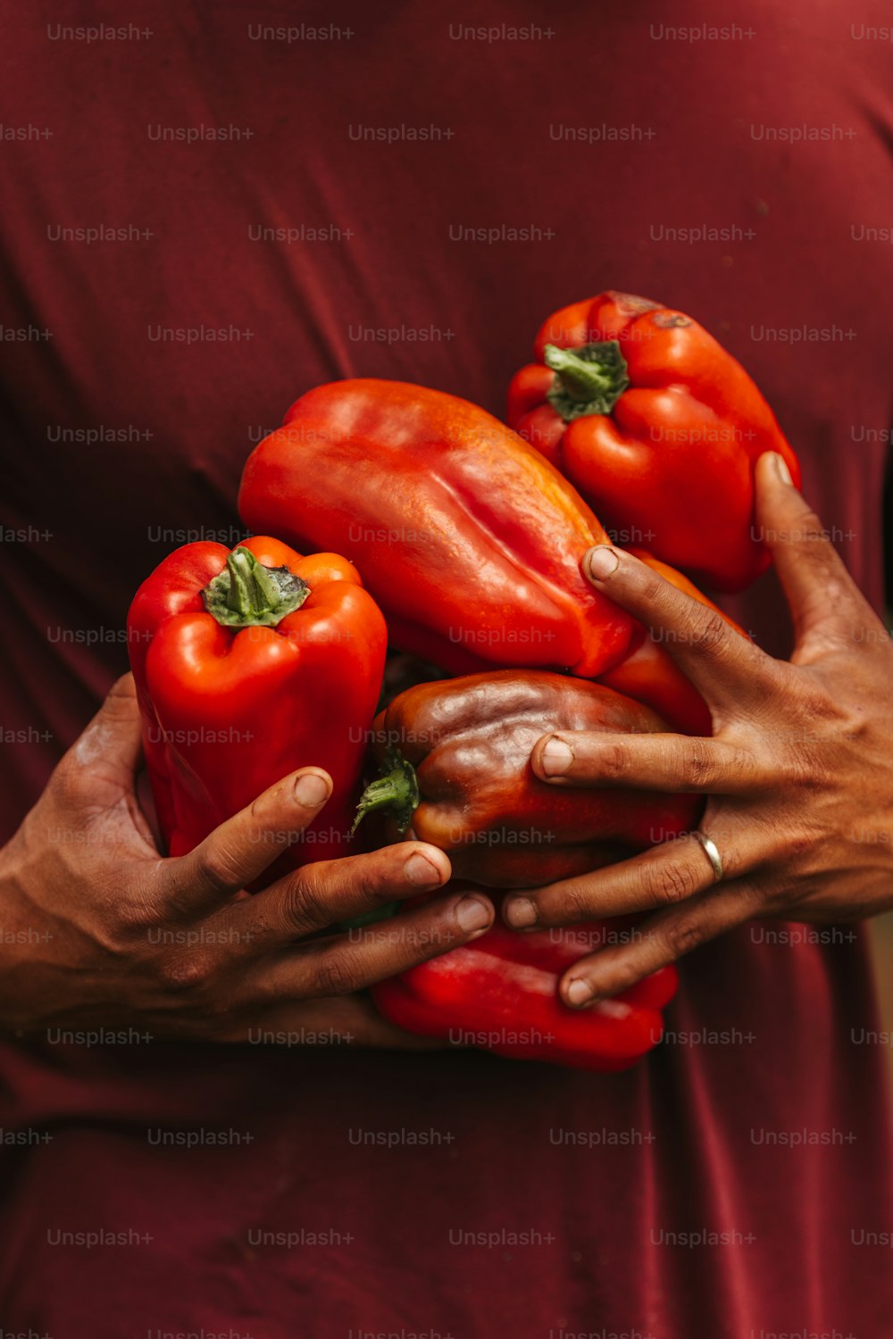a woman holding a bunch of red peppers