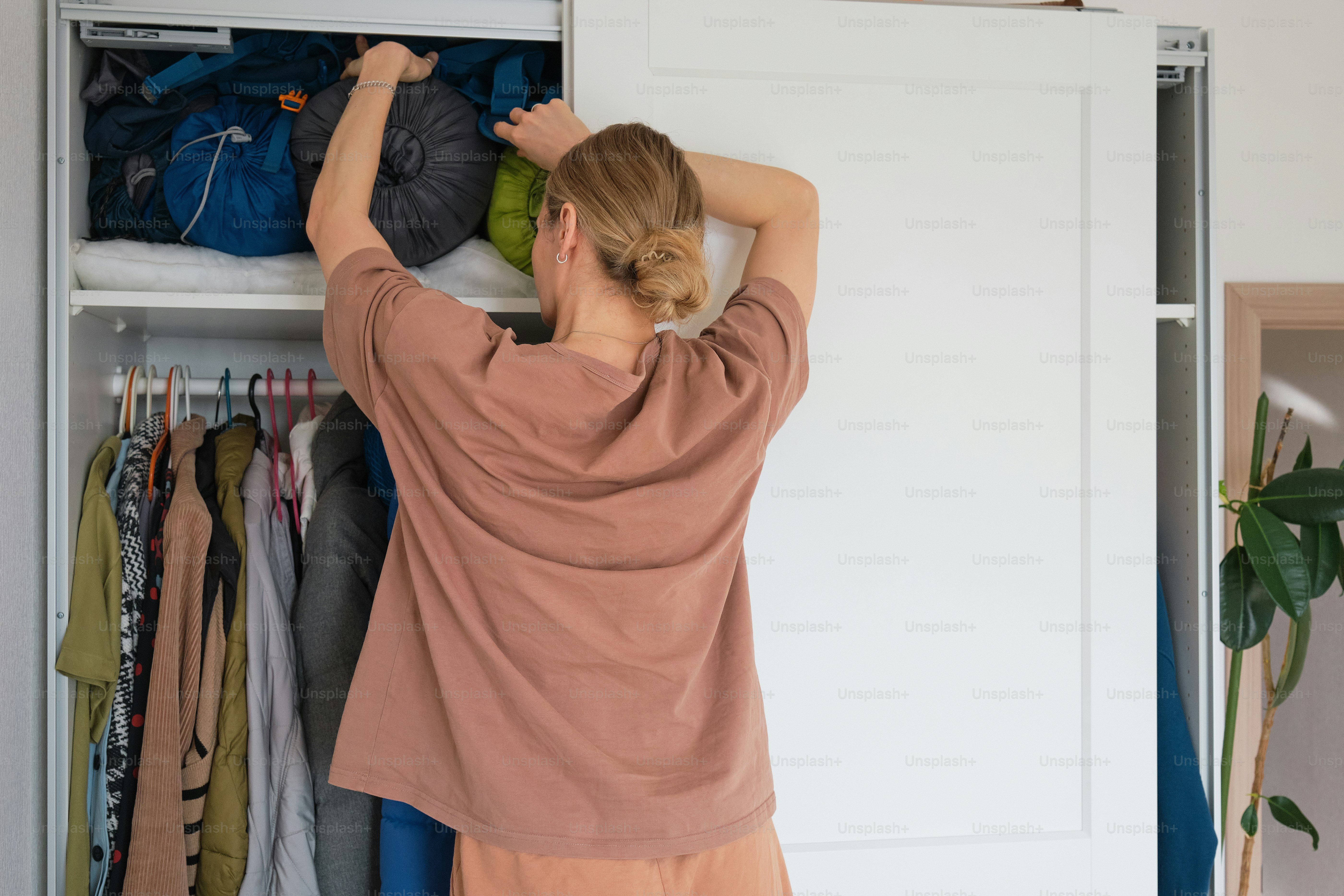 a woman standing in front of a closet filled with clothes