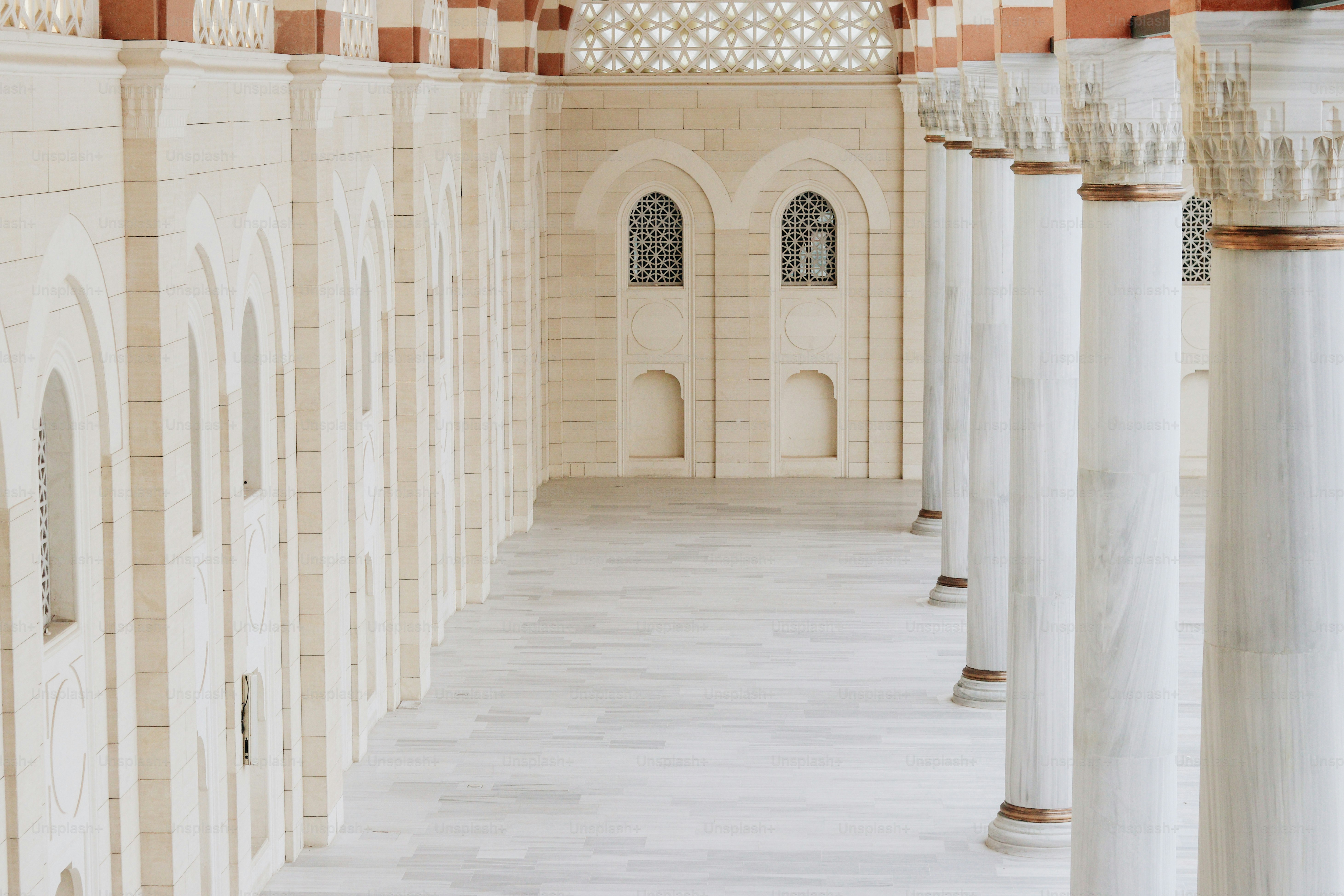a large room with columns and a clock on the wall