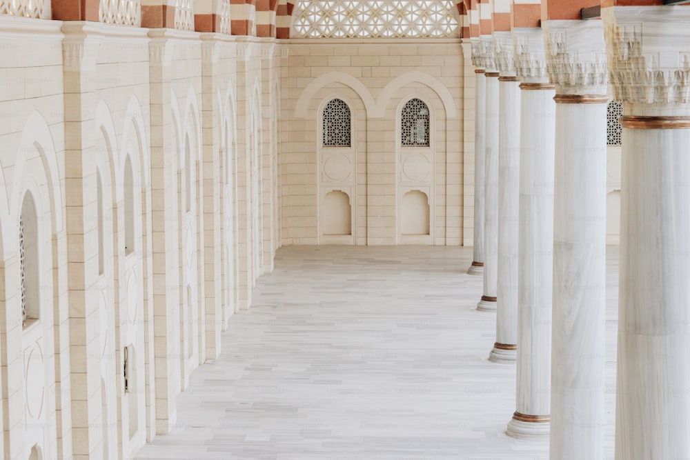 une grande salle avec des colonnes et une horloge au mur