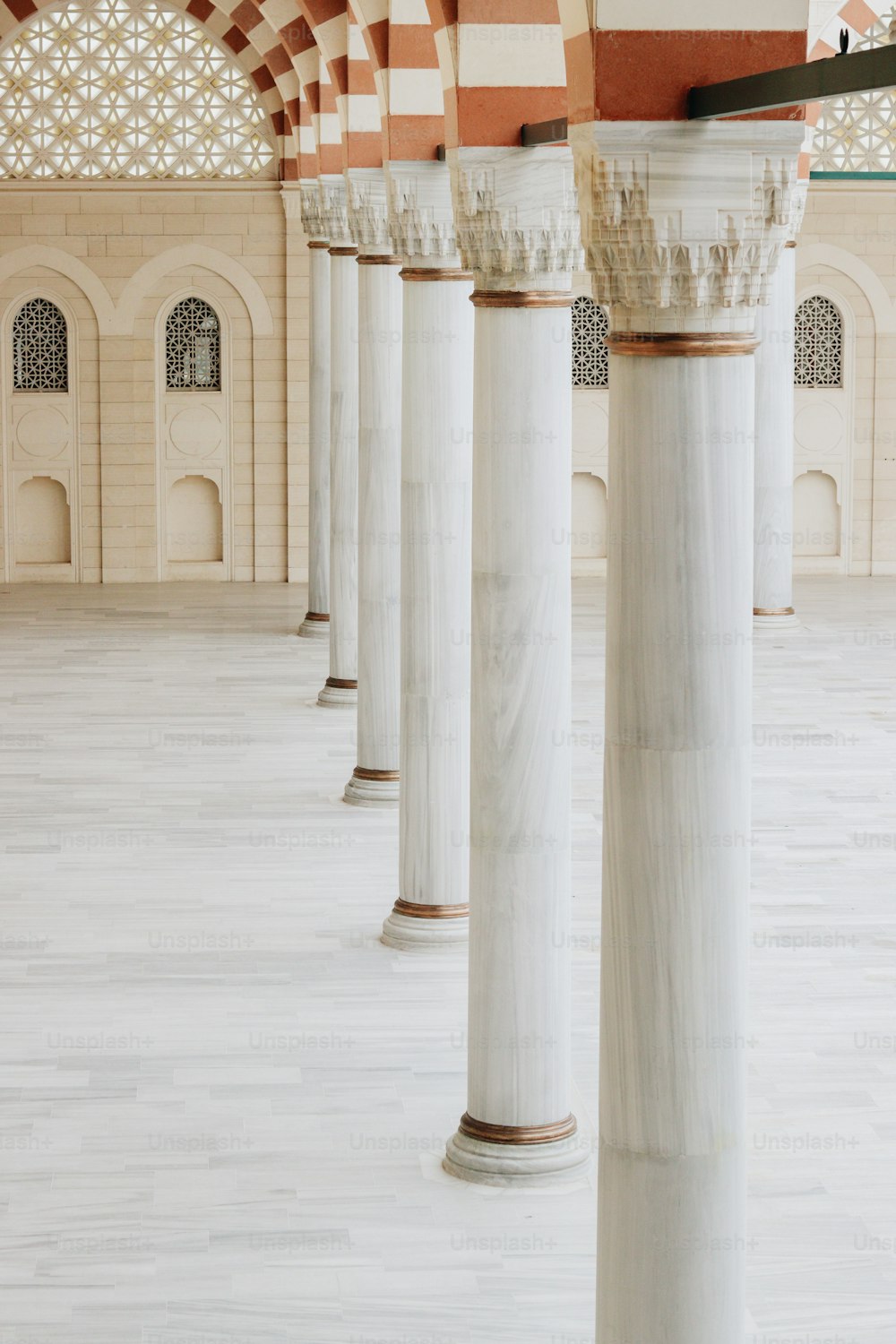 uma fileira de pilares de mármore branco em um edifício