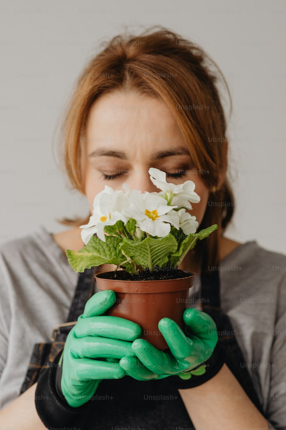 a woman holding a potted plant with white flowers