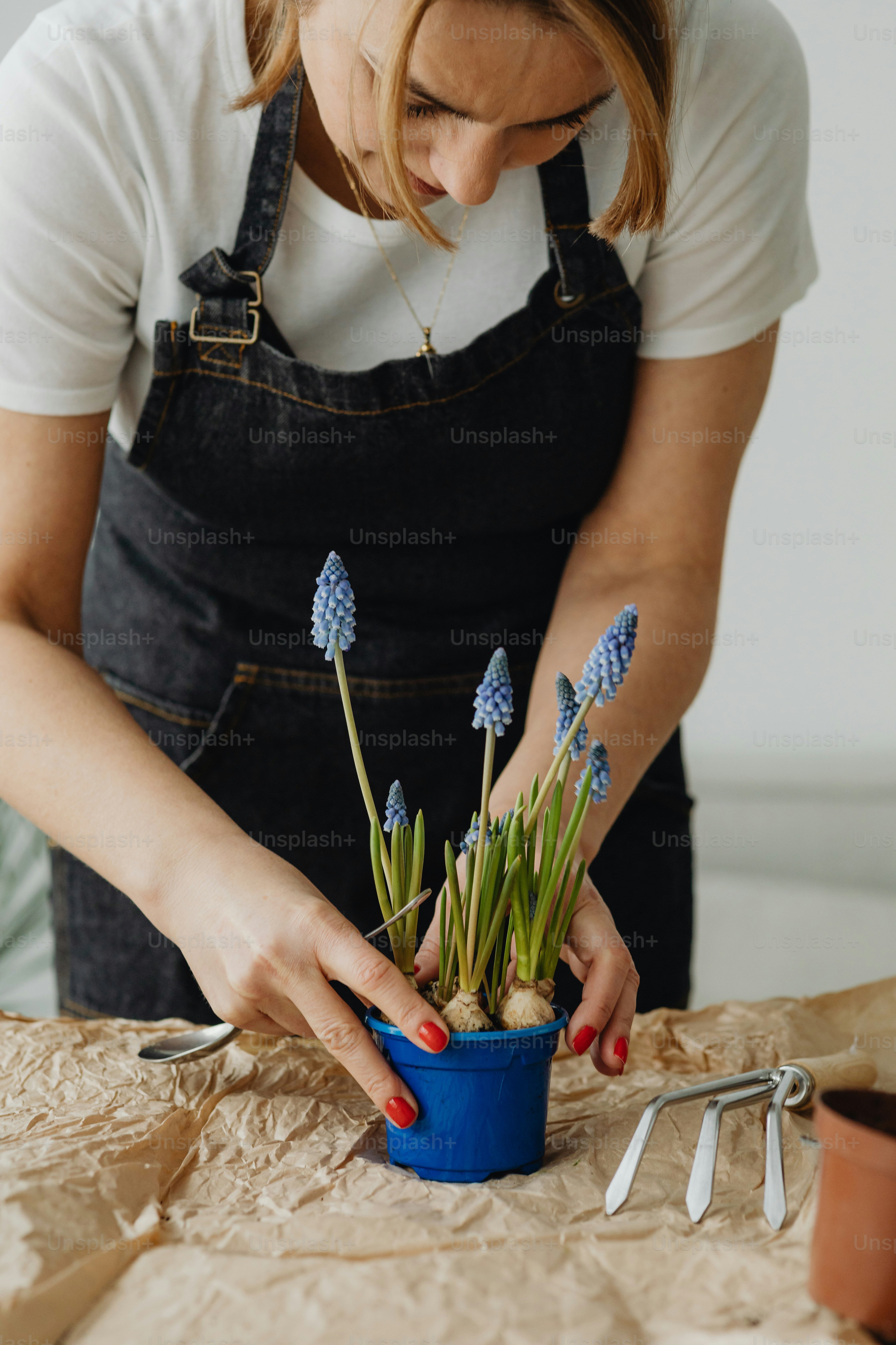 a woman is arranging flowers in a blue pot