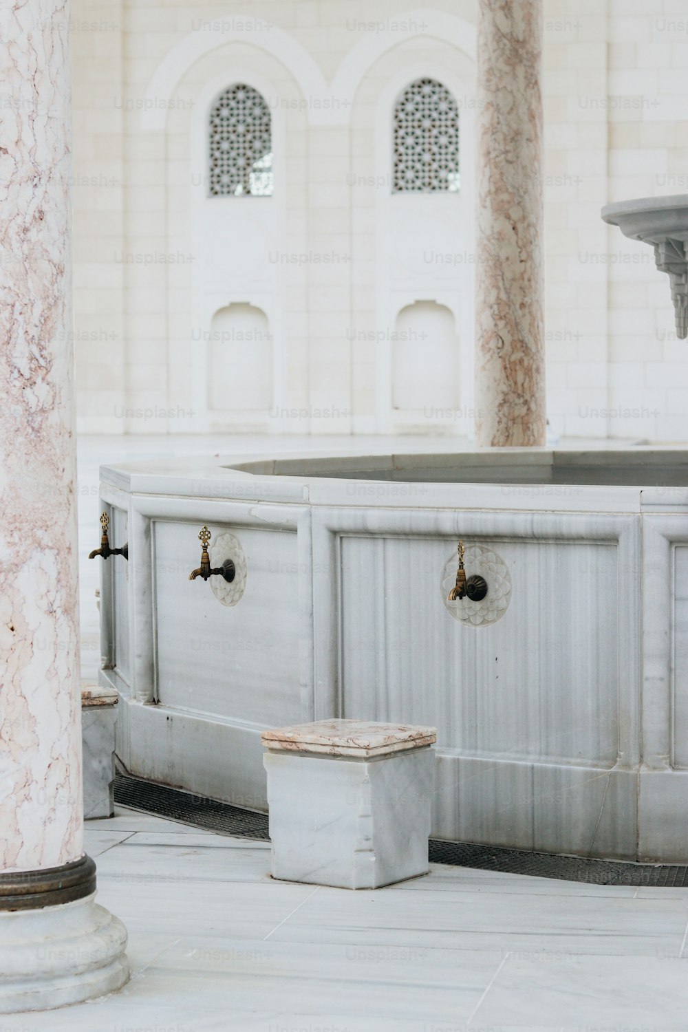 a white marble building with a fountain in the middle of it