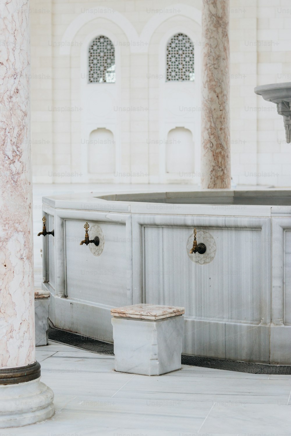 un bâtiment en marbre blanc avec une fontaine au milieu