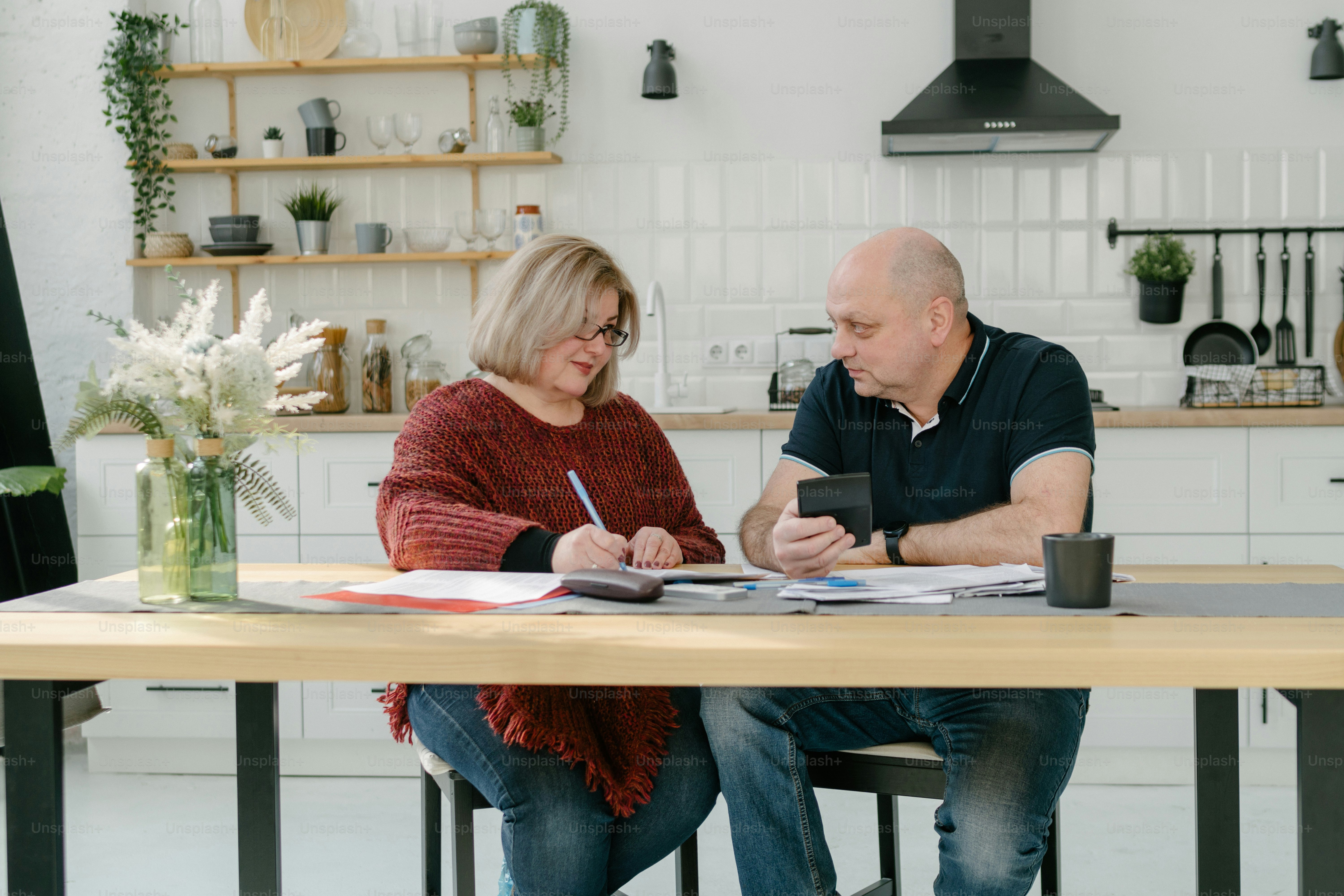 Ein Mann und eine Frau sitzen an einem Küchentisch
