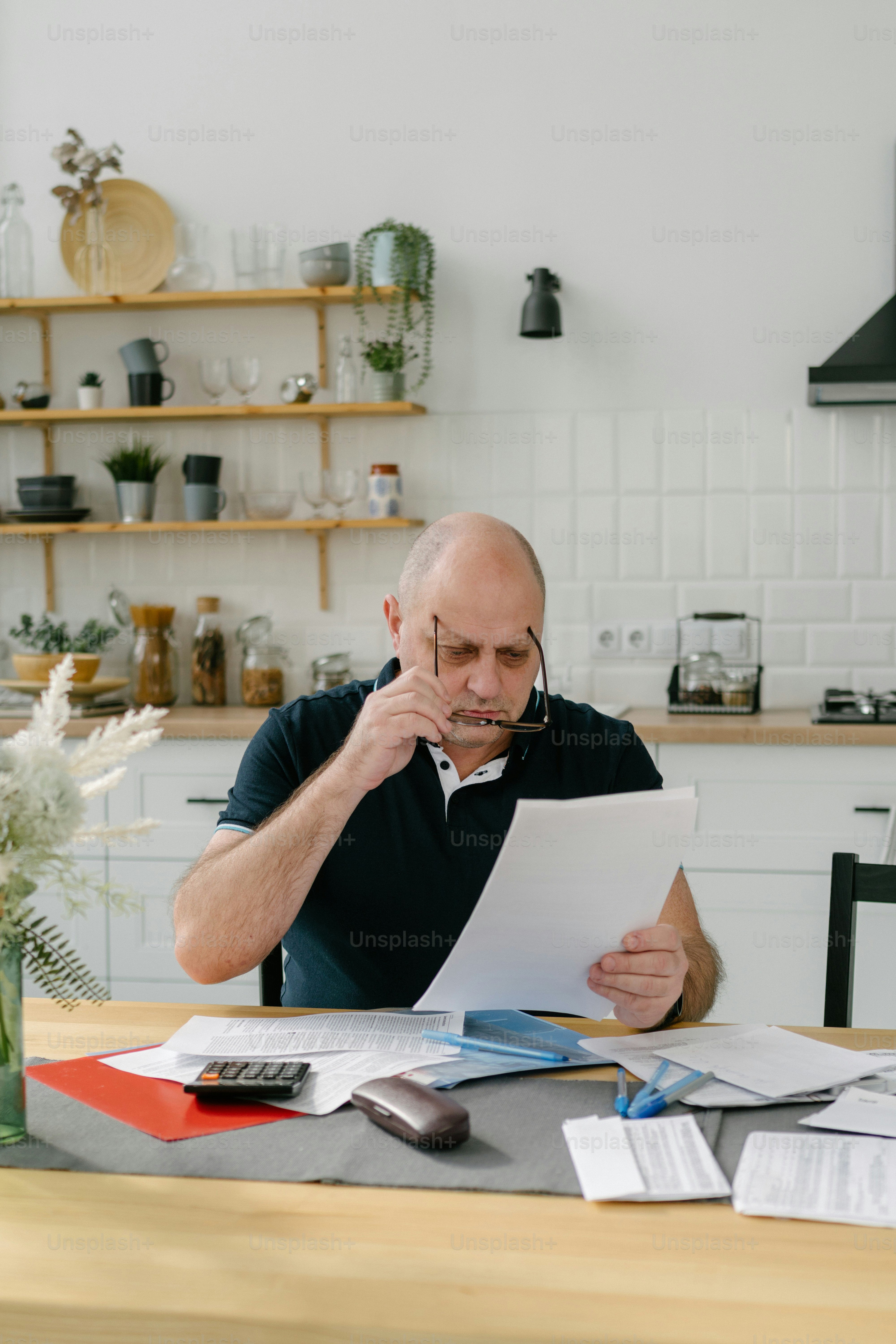Ein Mann sitzt an einem Tisch mit Papieren vor sich