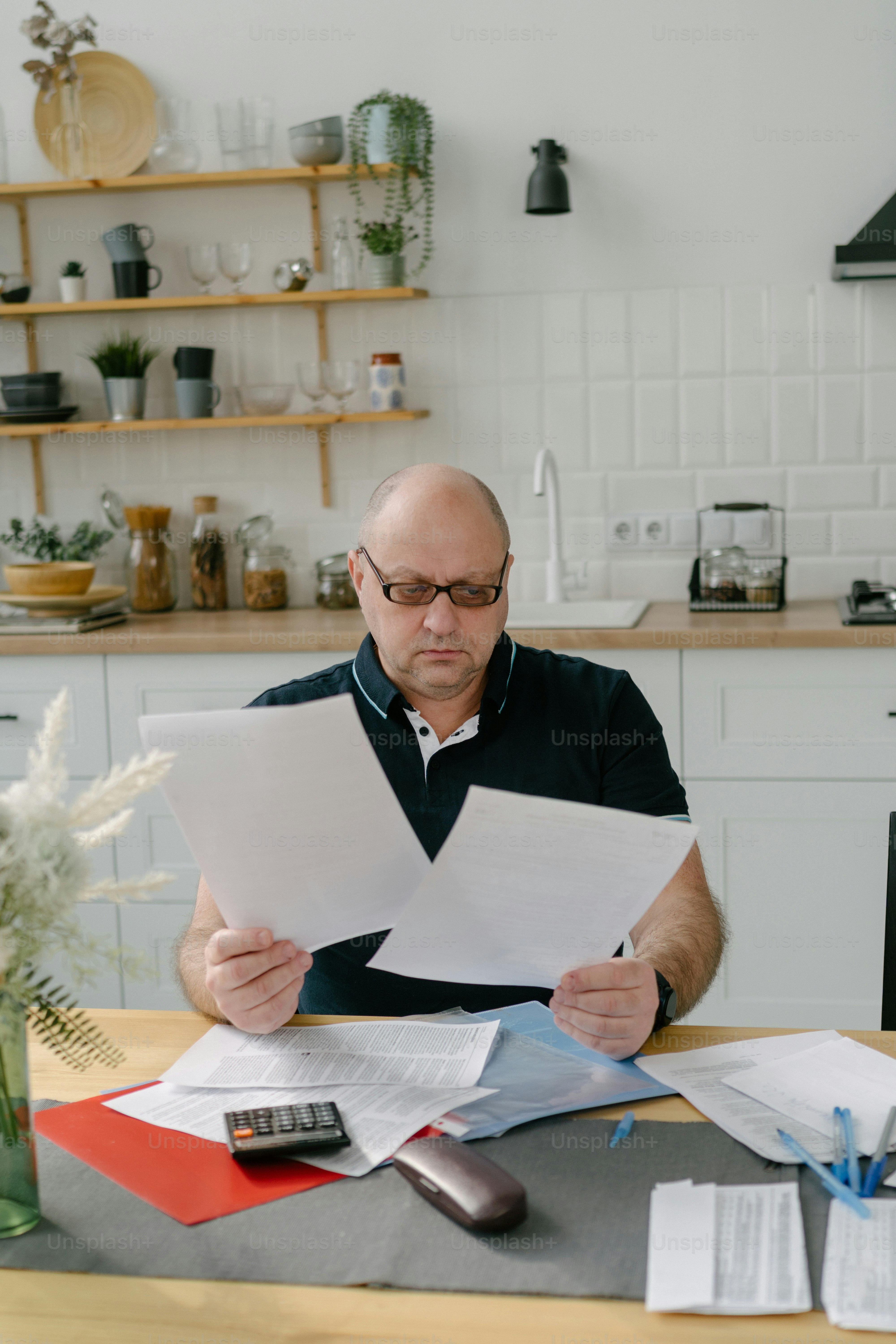 Ein Mann sitzt an einem Tisch mit Papieren vor sich