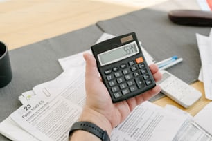 a person holding a calculator in their hand