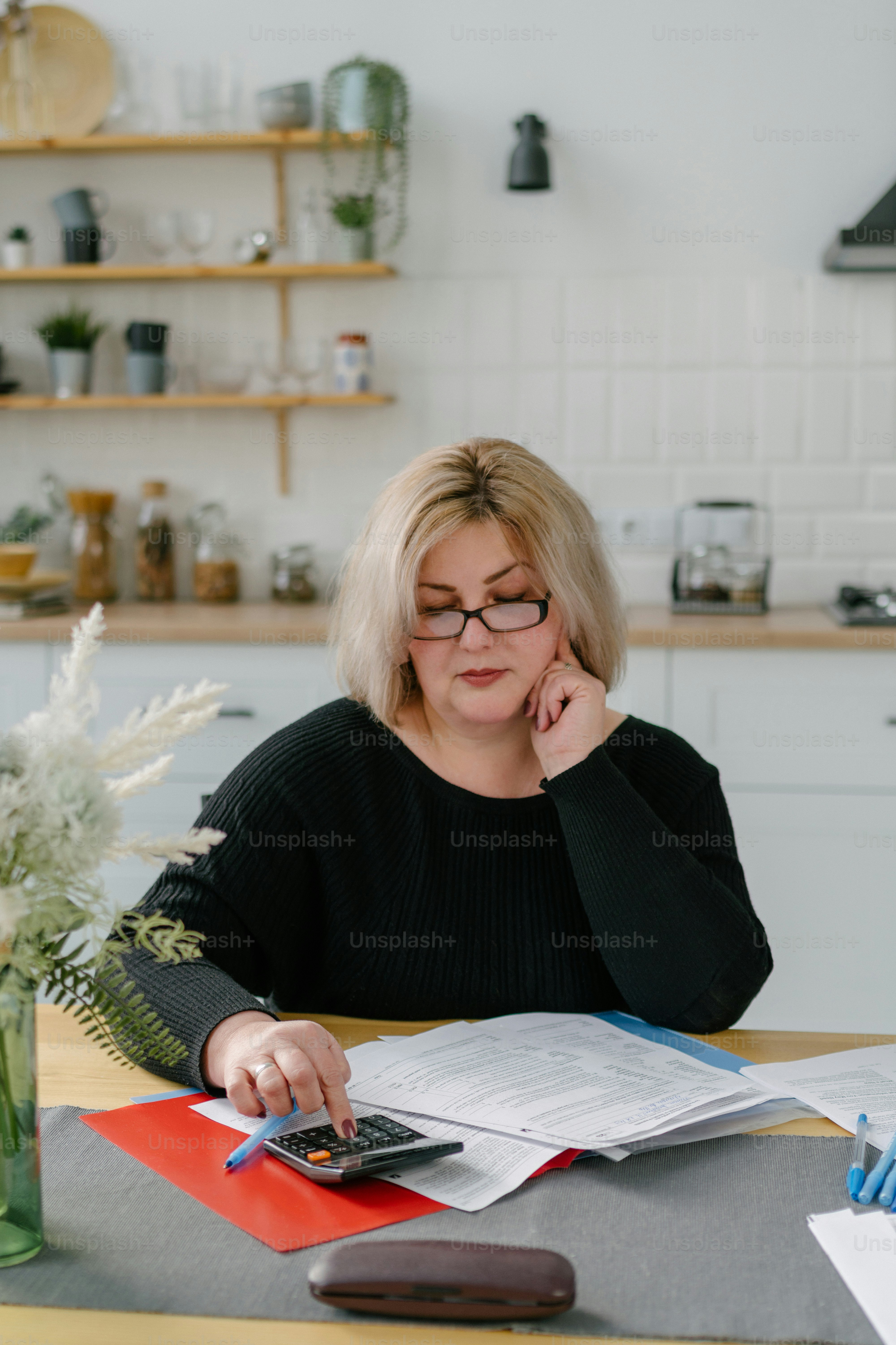 a woman sitting at a table with a calculator