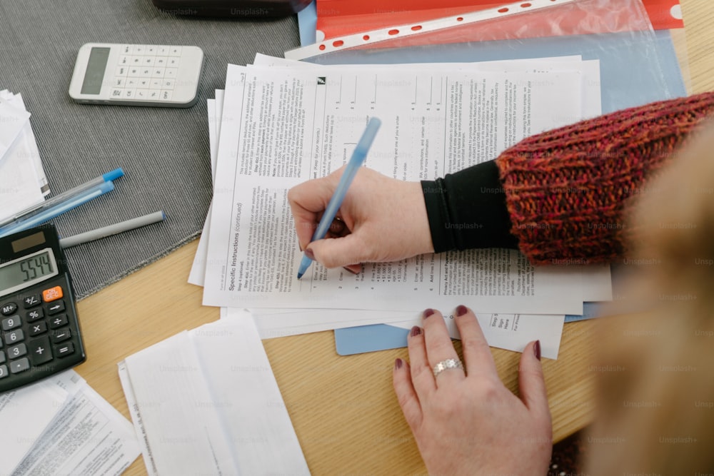 a woman sitting at a desk with papers and a calculator