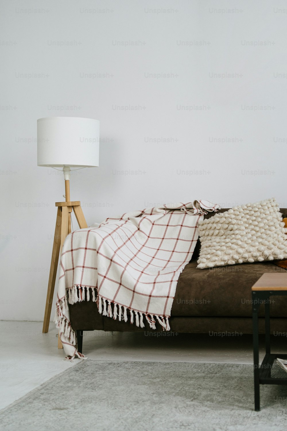 a living room with a brown couch and a white lamp