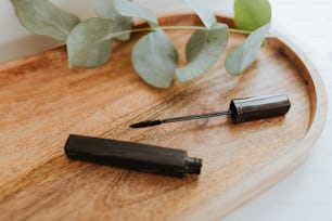 a close up of a black mascara on a wooden tray