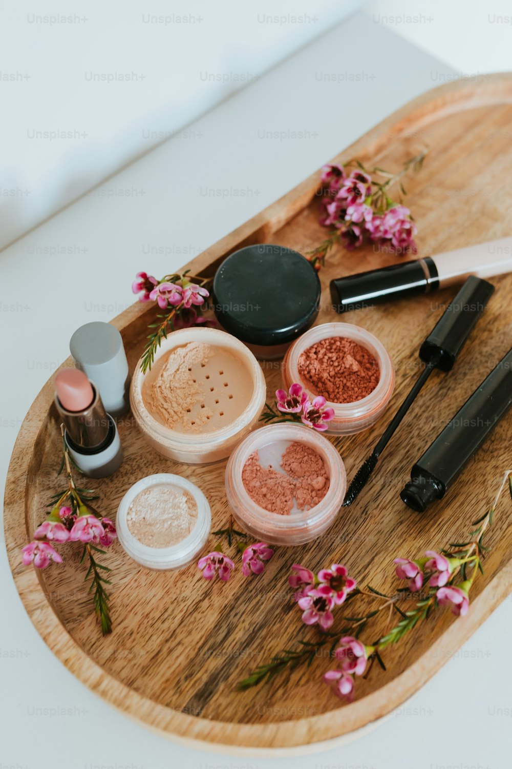 a wooden tray topped with different types of makeup