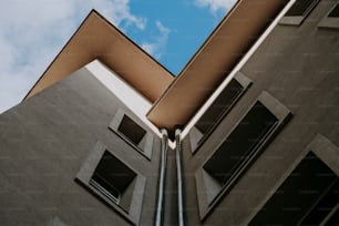 a tall building with two windows and a sky background