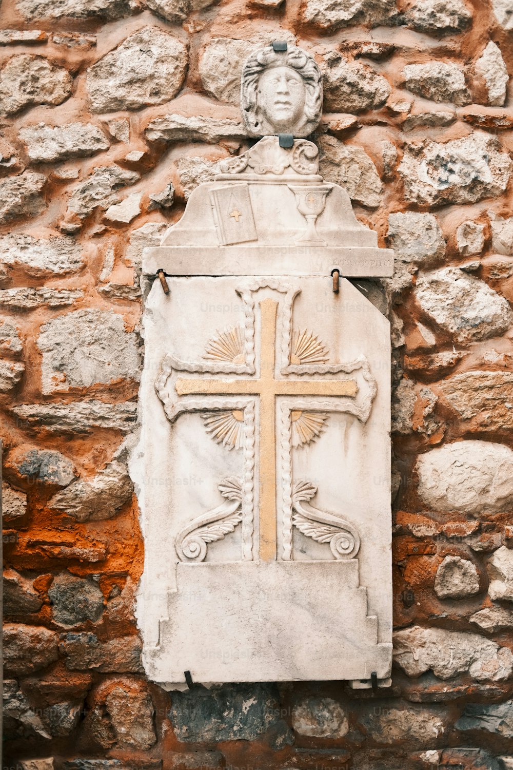 a stone wall with a cross on it