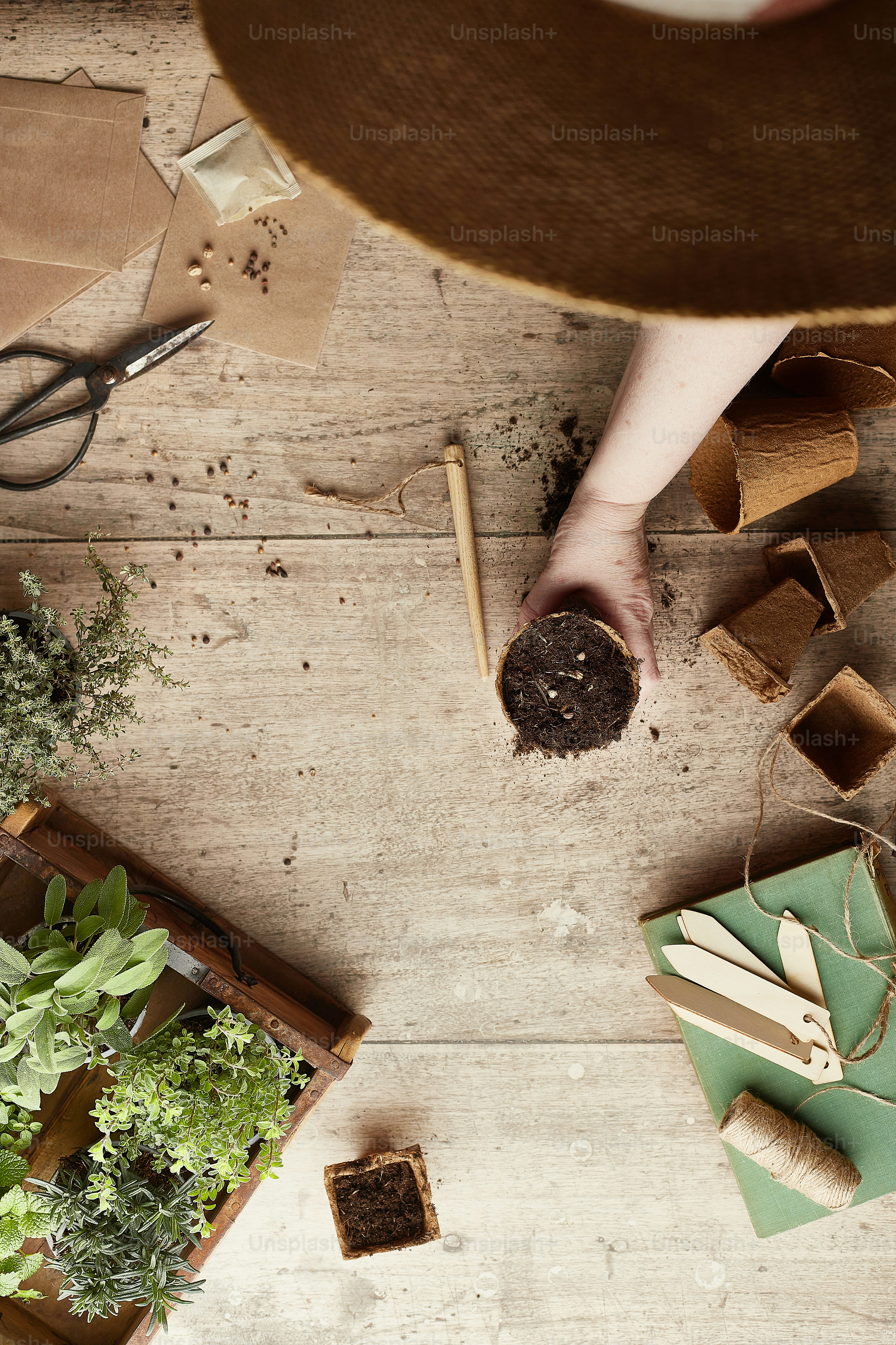 uma pessoa com um chapéu e ferramentas de jardinagem em um piso de madeira