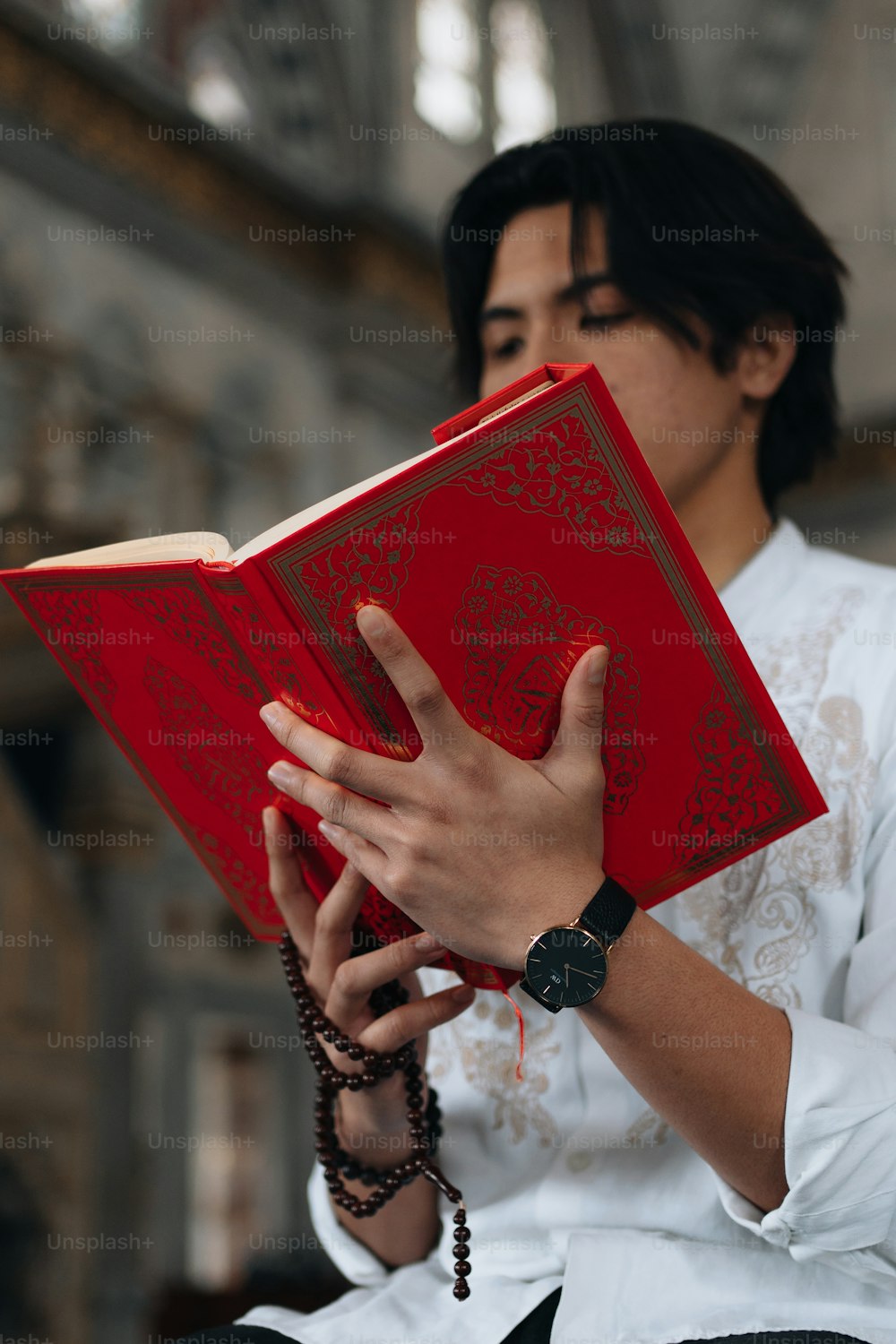 uma mulher segurando um livro vermelho em suas mãos