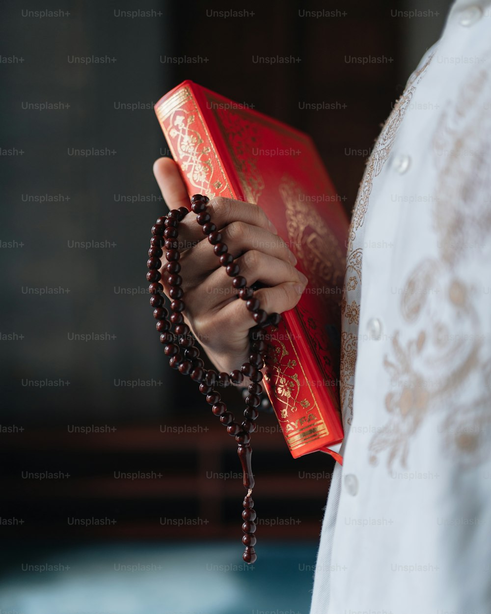 a person holding a rosary and a book