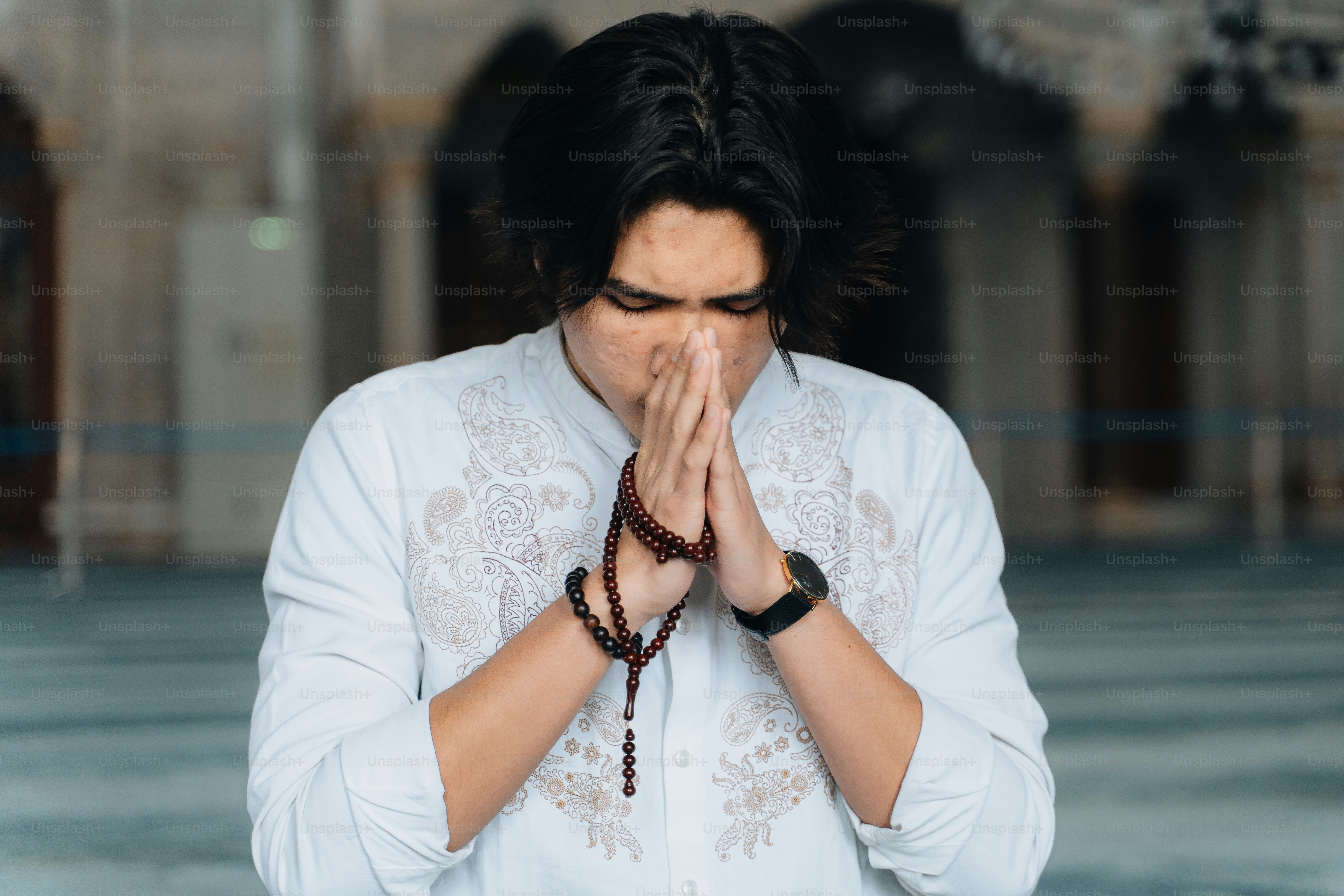 a man in a white shirt is praying
