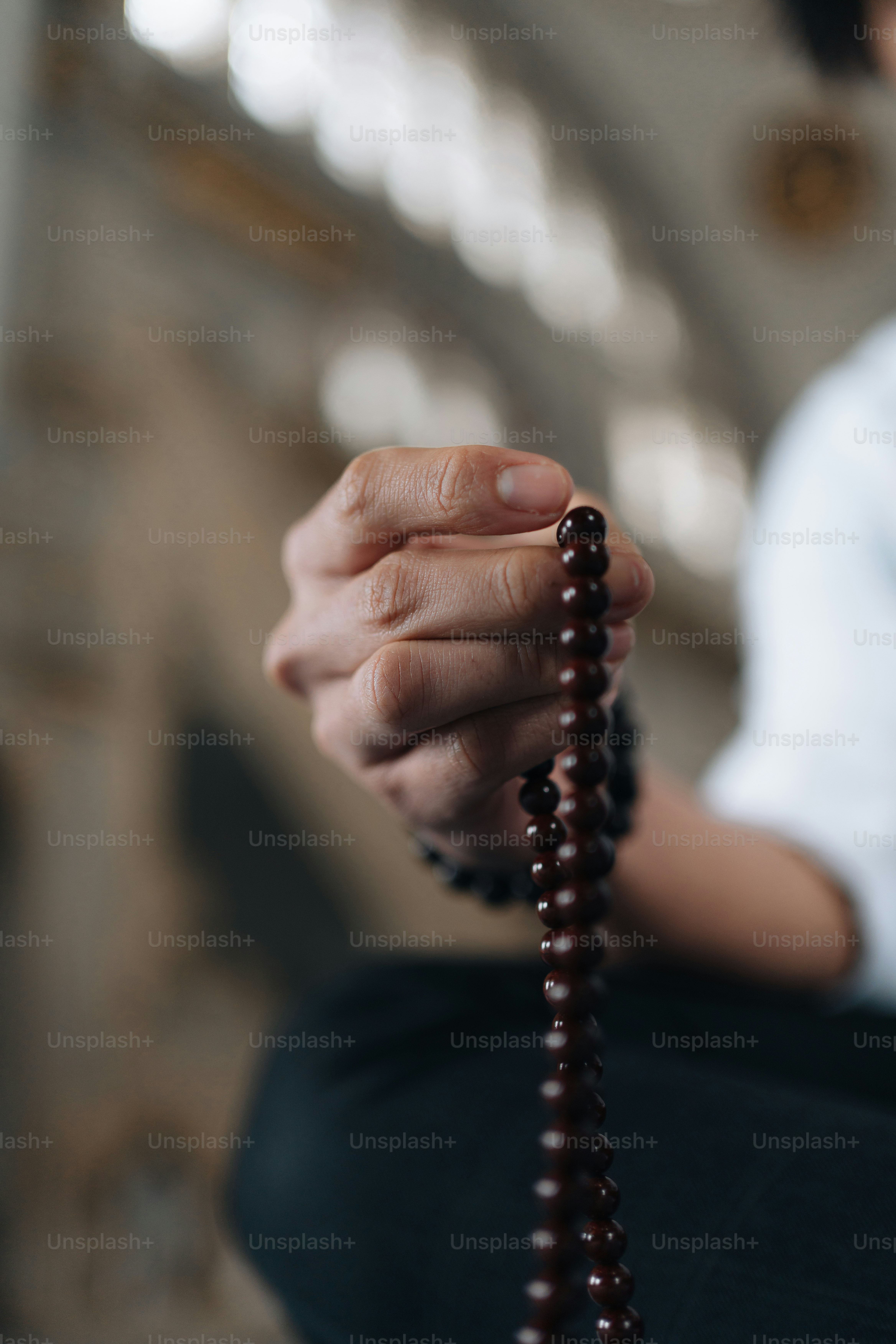 A Person Sitting On The Ground Holding A Rosary Photo – Halal Image On ...