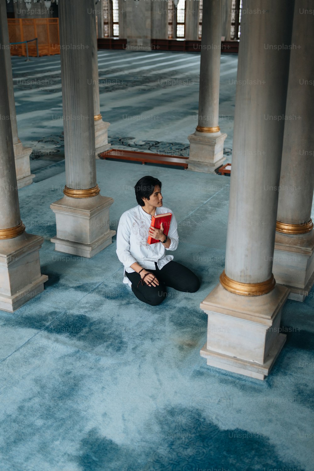 a woman sitting on the floor reading a book