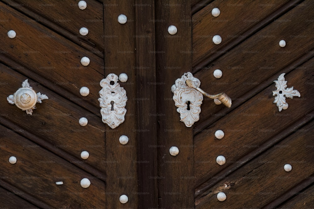 a close up of a wooden door with white knobs