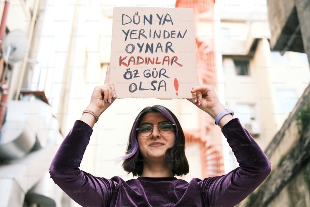 a woman holding up a sign in the air