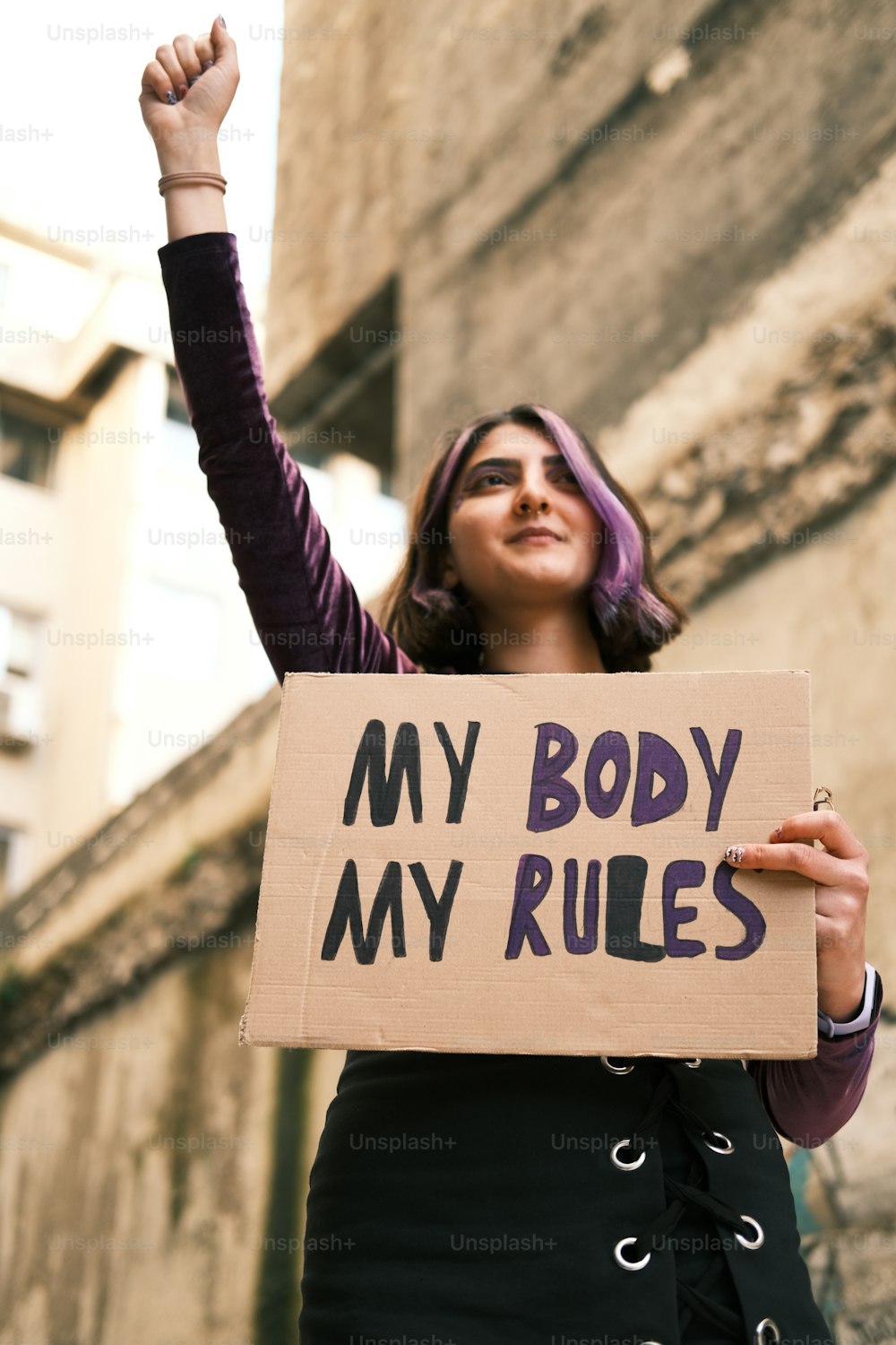 a woman holding a sign that says my body my rules