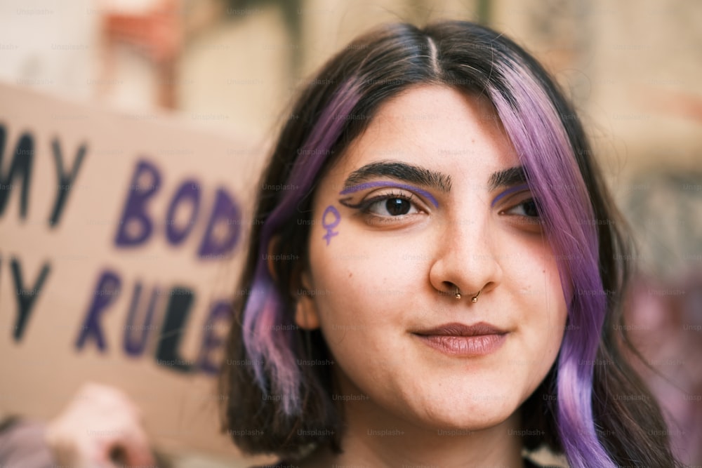 a woman with purple hair holding a sign