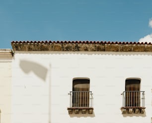 a white building with two windows and a street sign