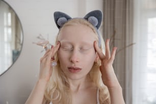 Une femme aux cheveux blonds portant un chapeau d’oreilles de chat