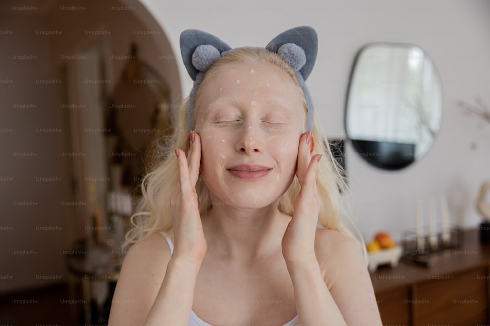 a woman with her eyes closed wearing a cat hat