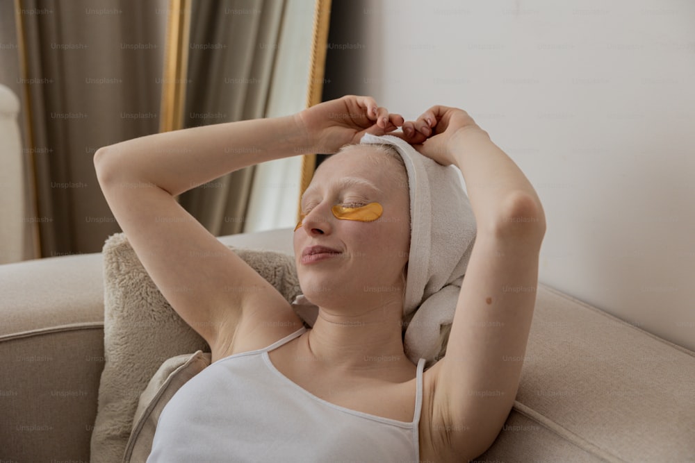 Eine Frau mit einem Handtuch auf dem Kopf und gelben Flecken auf den Augen