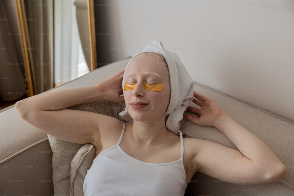 une femme avec une serviette sur la tête et des cache-yeux jaunes sur le visage