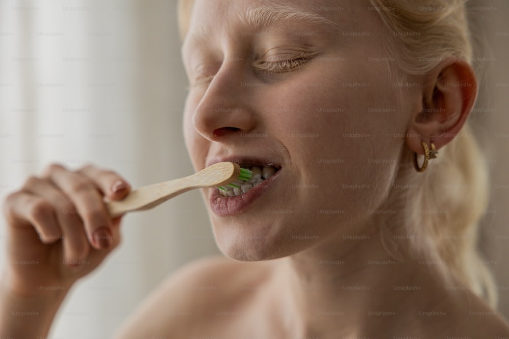 Una mujer cepillándose los dientes con un cepillo de dientes