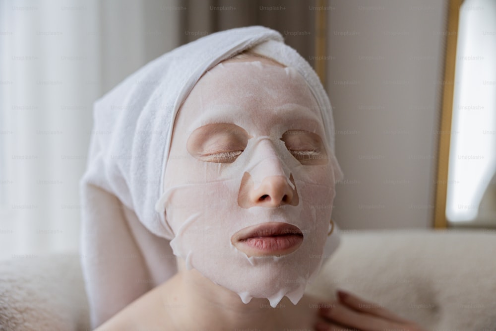 a woman wearing a white sheet mask on her face