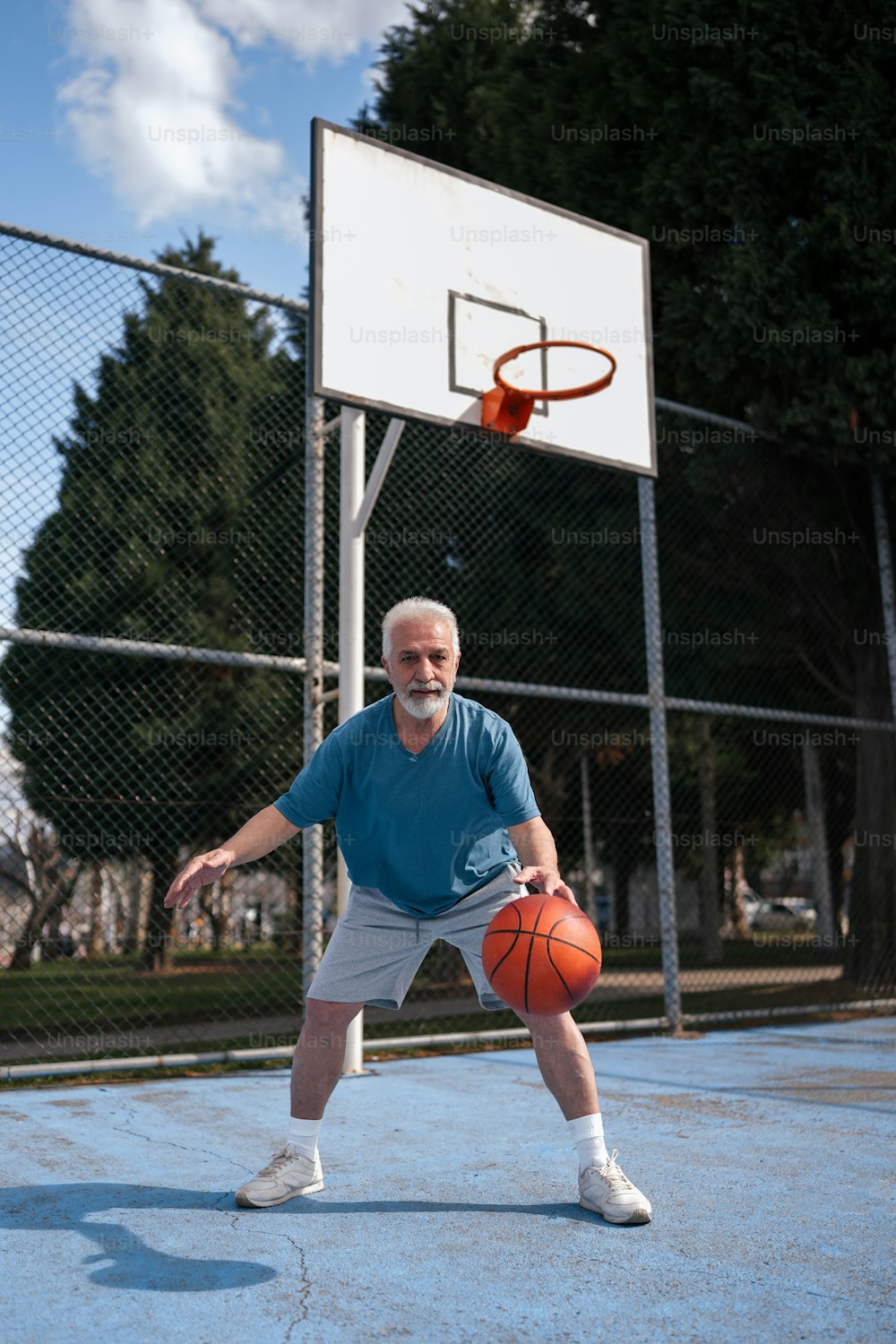 농구 골대 앞에서 농구공을 들고 있는 남자